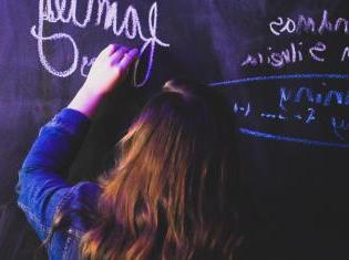 Student writing on blackboard